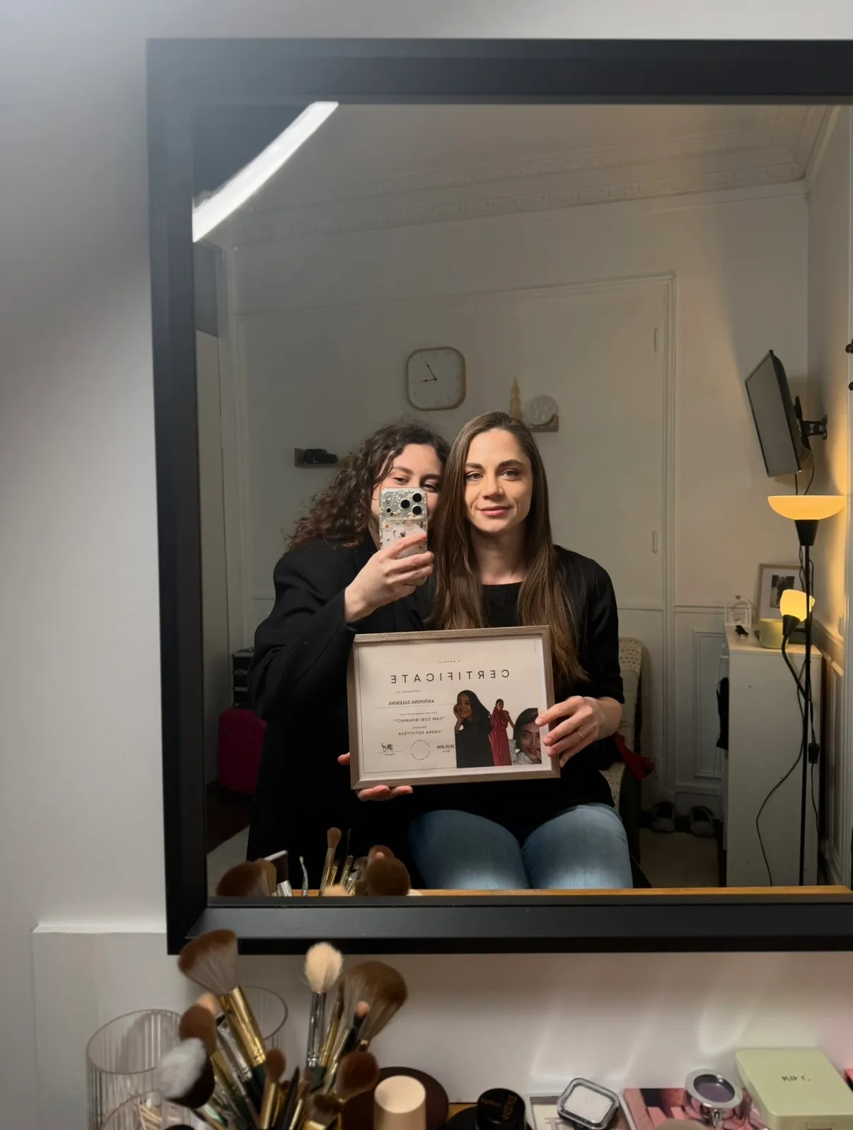 Une cliente diplômée tenant son certificat encadré